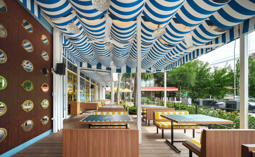 Outdoor terrace under a blue and white striped canopy at Beer Collection, Hua Hin
