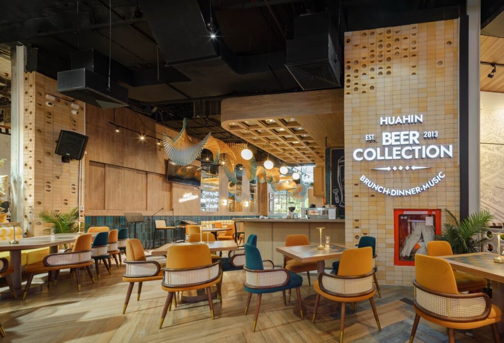 Perforated timber signage wall reading Huahin Beer Collection, with loose seating in the dining room