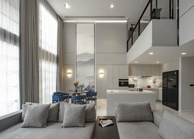 Open-plan duplex living room with mezzanine walkway, island kitchen and full-height curtains, Sukhumvit 31 Bangkok