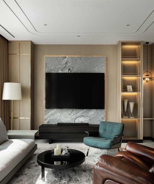 Four Seasons Private Residences Bangkok — living room with oak panelling, a marble media wall, lit display niches and a teal armchair against tan leather seating