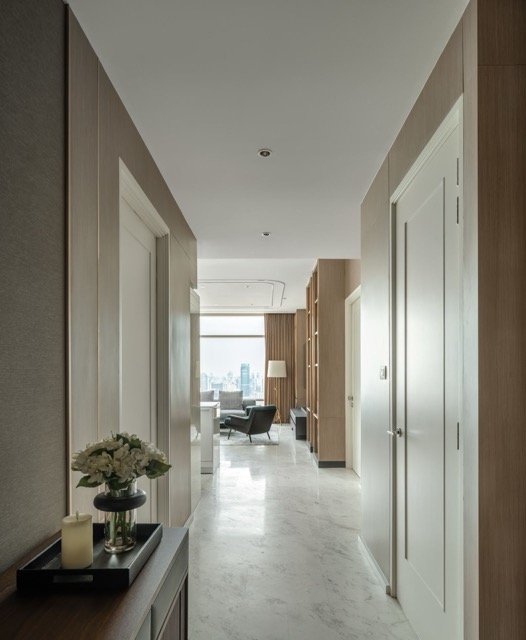 Entry corridor with marble floor and pale timber panelling leading to the living room