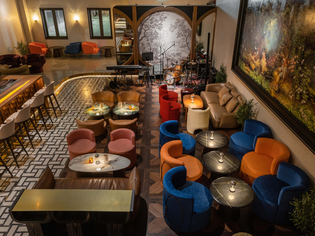 Overhead view of Kilik Social Club lounge seating in blue, red and cognac around the live-music stage