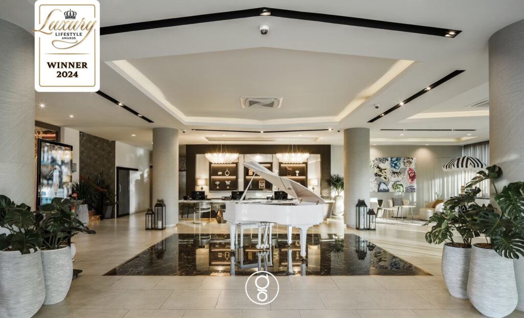 La Miniera Pool Villas lobby with white grand piano on black marble reflecting floor