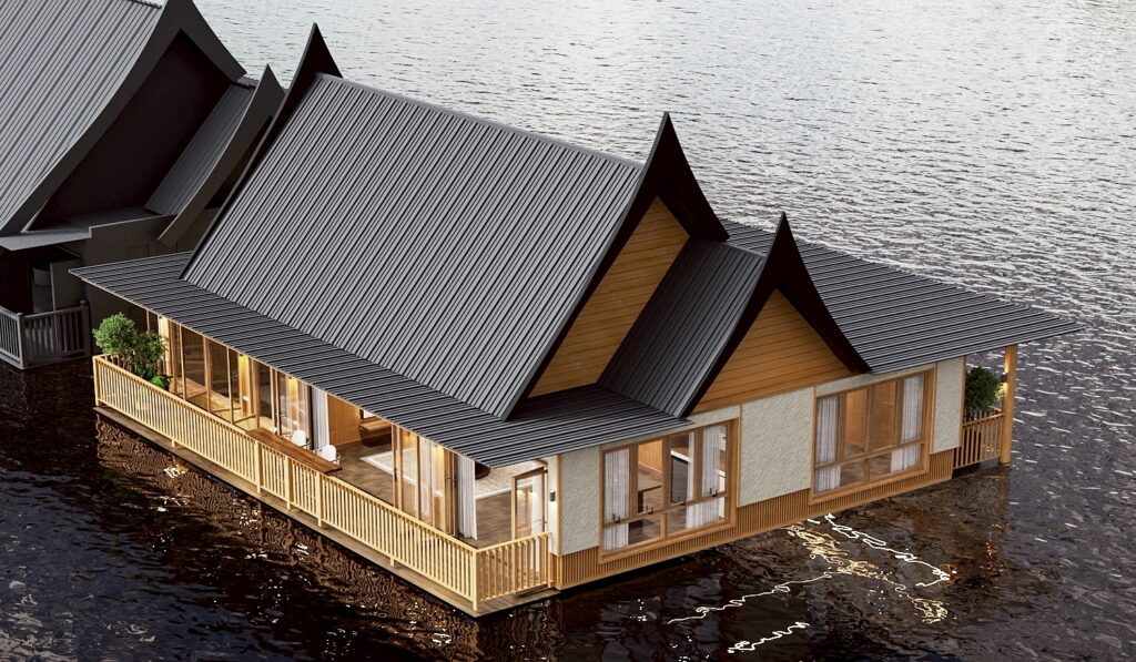 River Kwai Village floating villa — twin-gabled Thai-style villa with timber verandah railings resting on the river, architecture and interiors by Gratitude Design