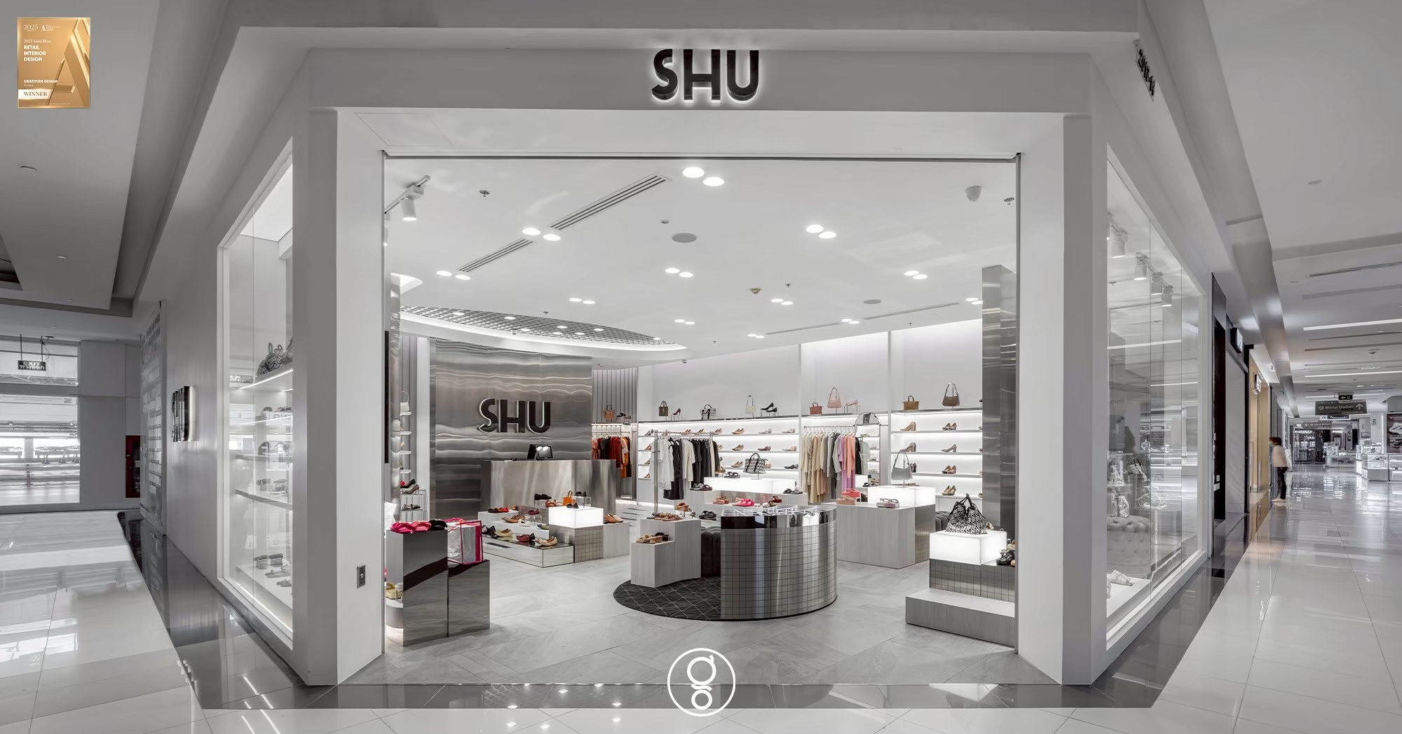 SHU shopfront seen from the mall concourse at Fashion Island, a full-glass frontage under black dimensional lettering