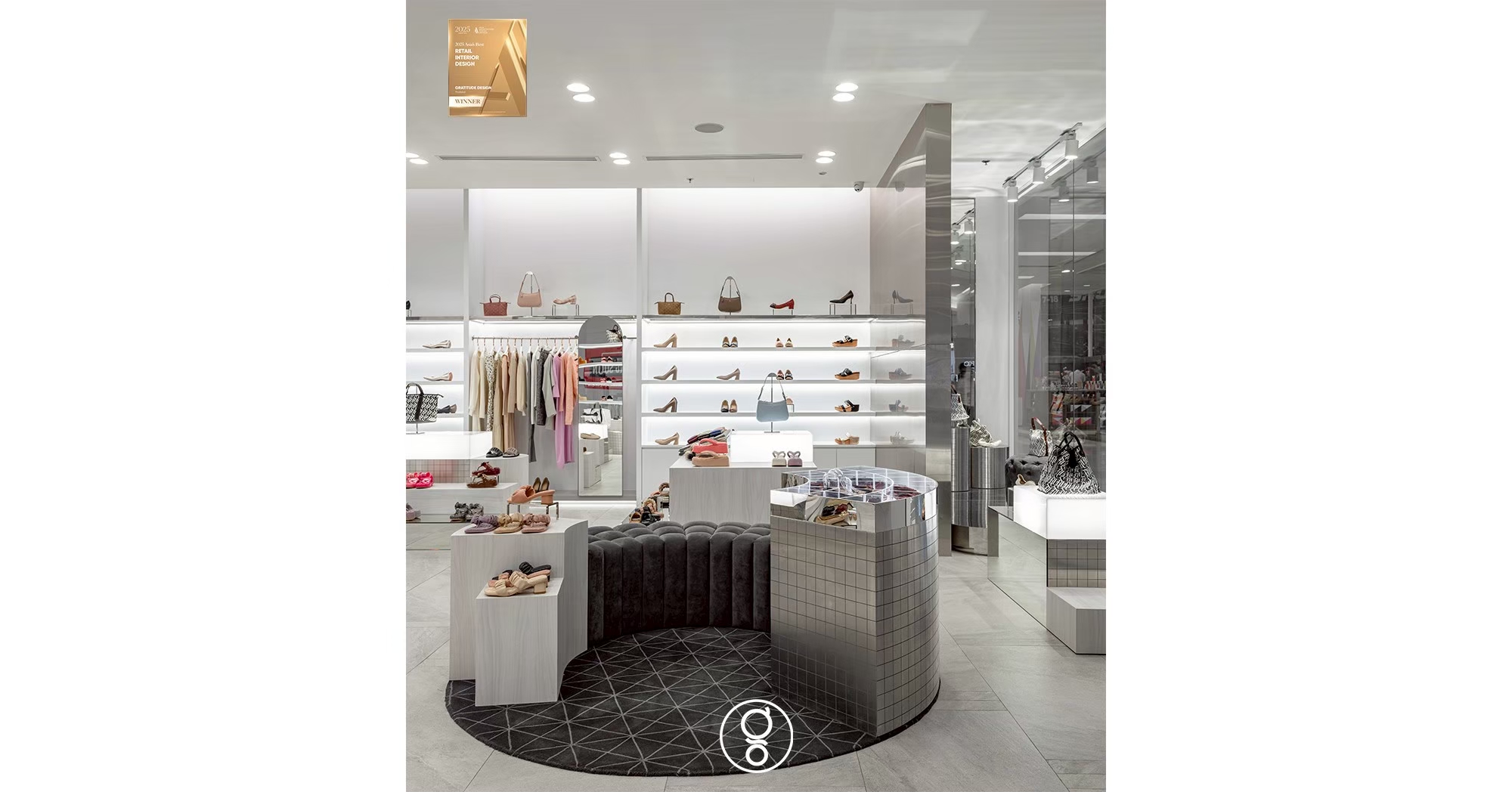 Grey velvet ottoman on a patterned rug at the centre of the SHU shop floor, surrounded by lit display plinths