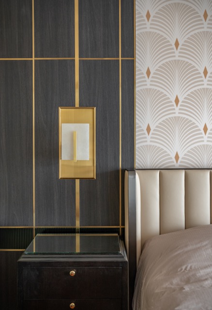 Art Deco master bedroom detail with brass inlay panelling, alabaster sconce and fan-patterned wallpaper