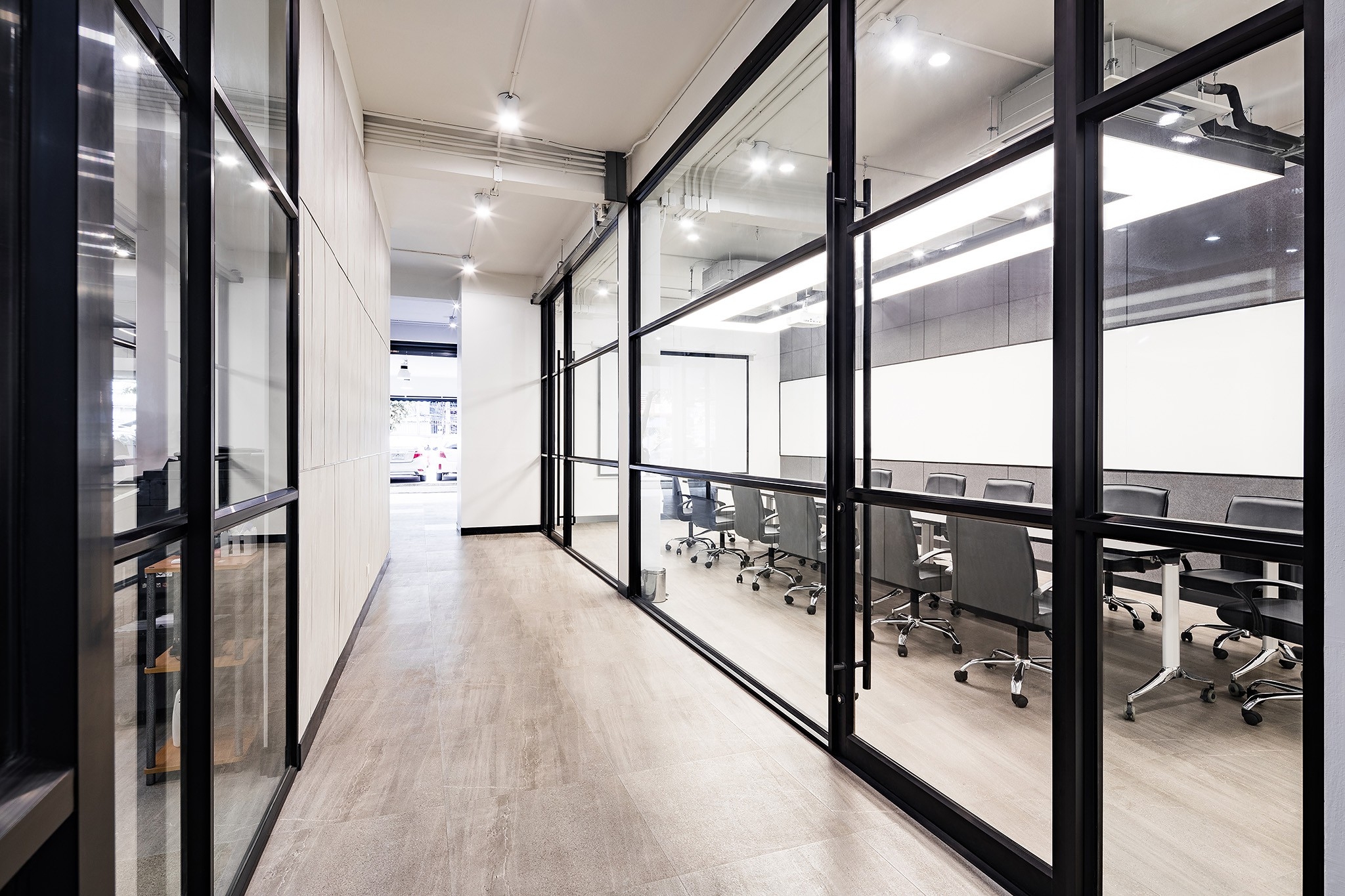 Head office interior design in Bangkok — corridor between glazed meeting rooms and the service core