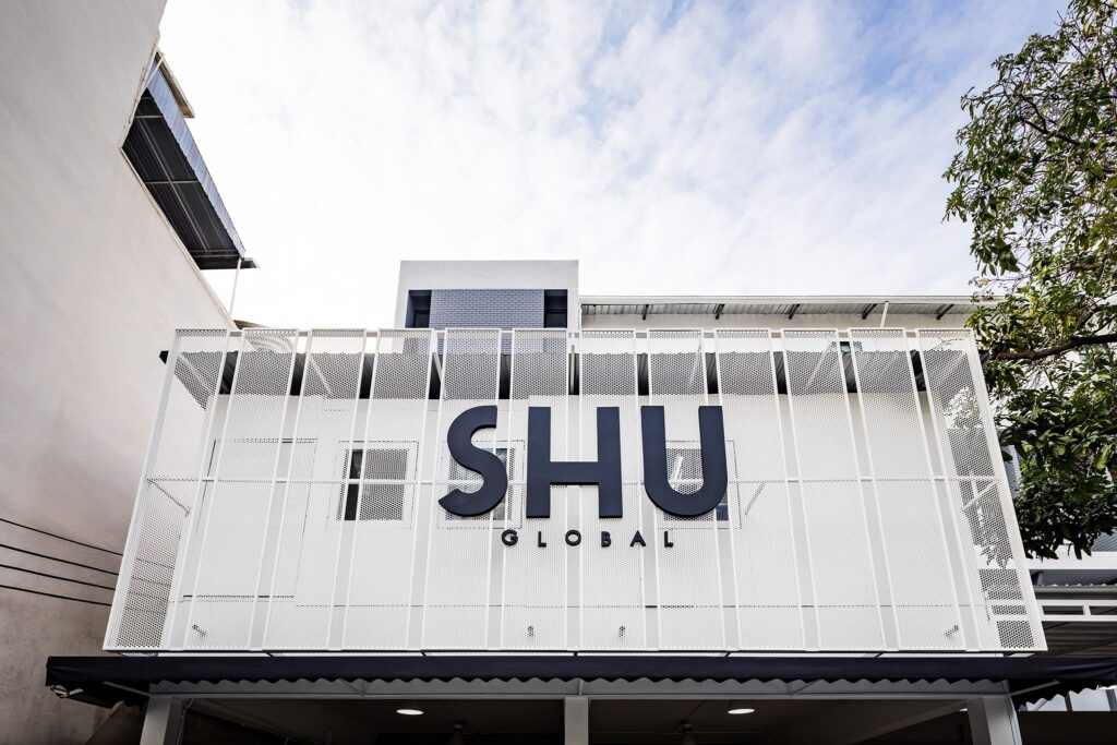 SHU HQ and flagship store facade in Bangkok — perforated white metal screen, retail and workplace interior design by Gratitude Design