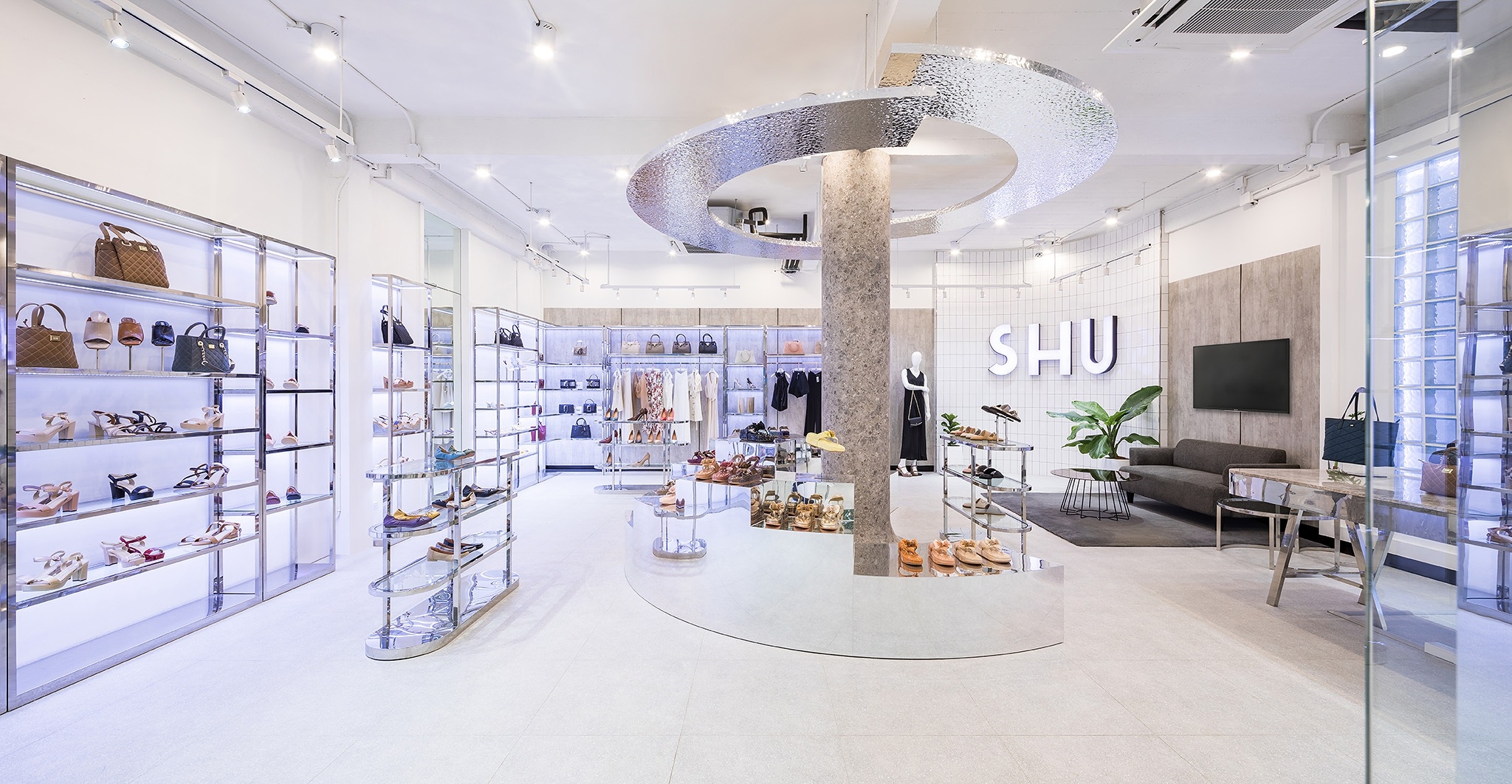 Shoe store interior design in Bangkok — mirror-polished plinth running the length of the shop floor