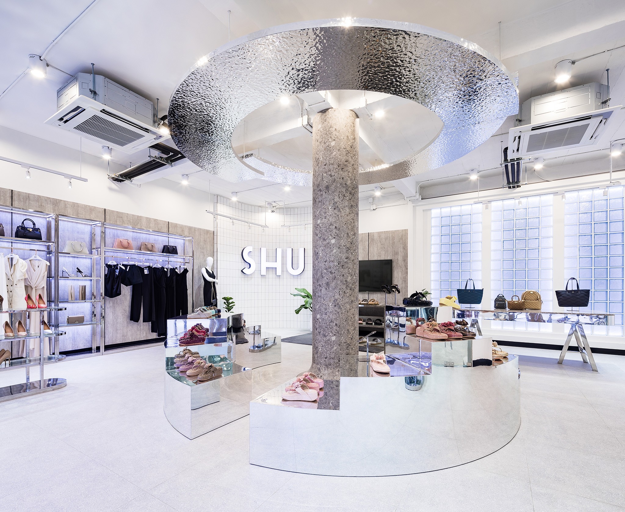 Retail interior design in Bangkok — apparel and footwear displayed under a stainless steel ring ceiling