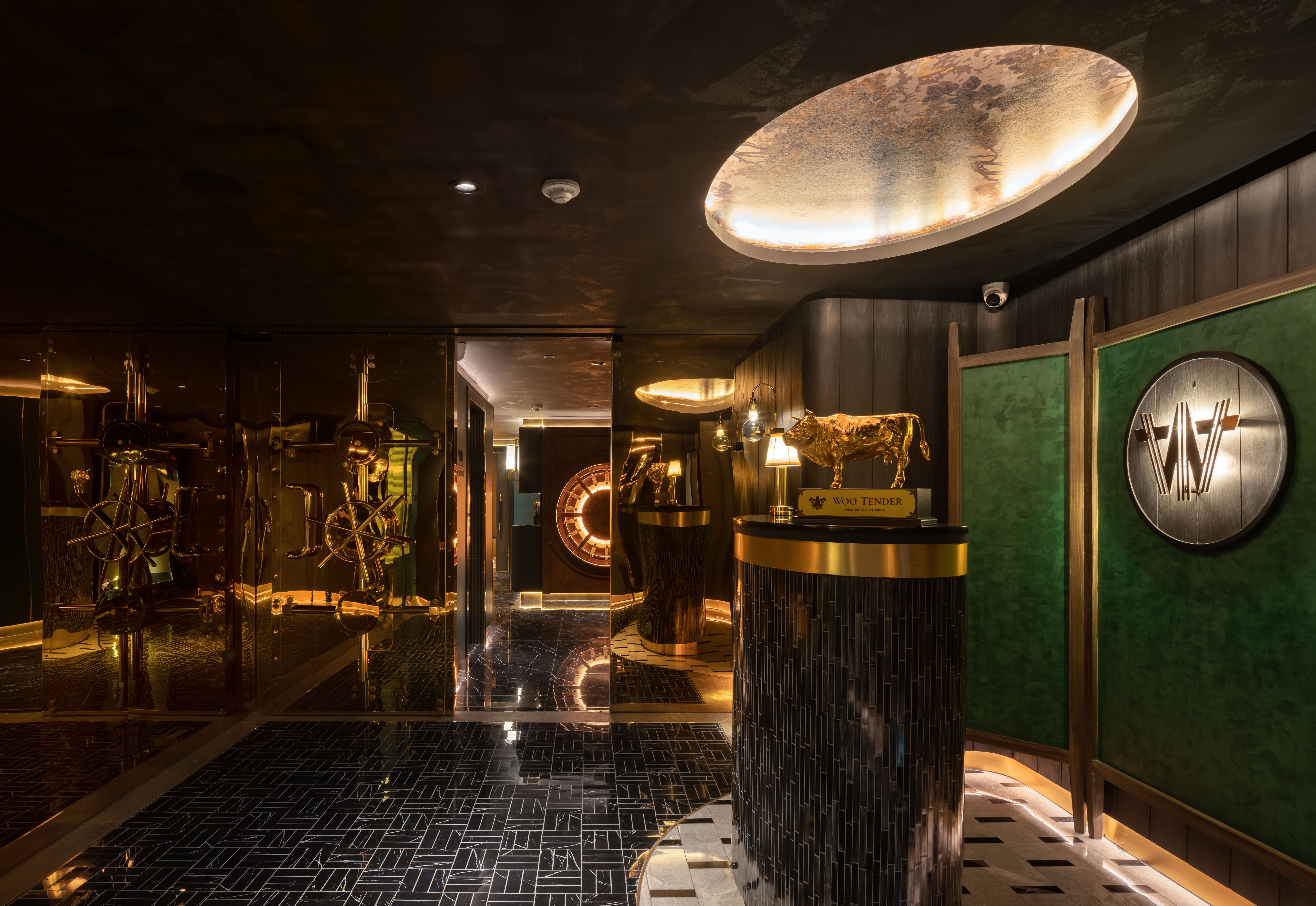 Oval light over the circulation with brass and green panelling