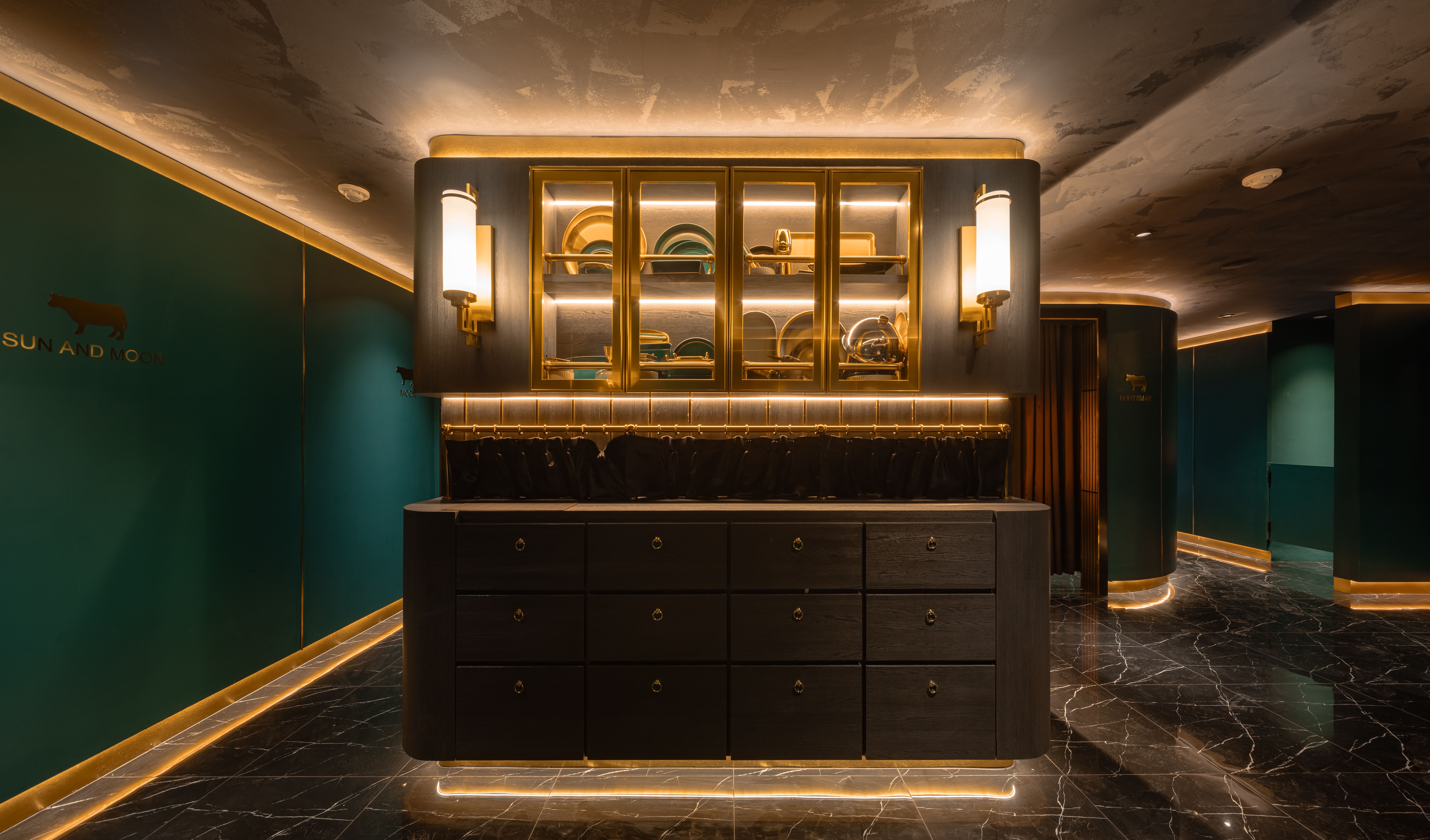 Backlit service cabinet in dark timber and brass