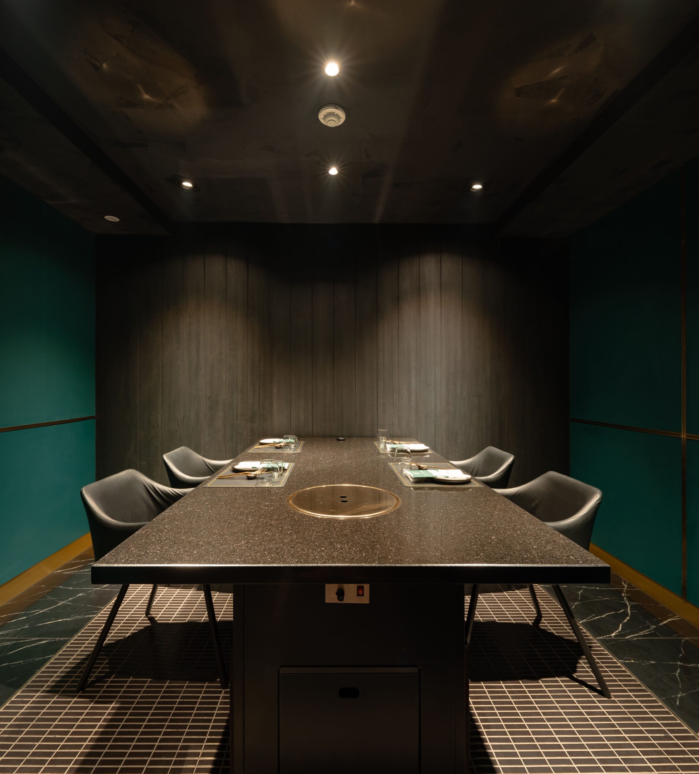 Private dining room with a stone table and teal walls