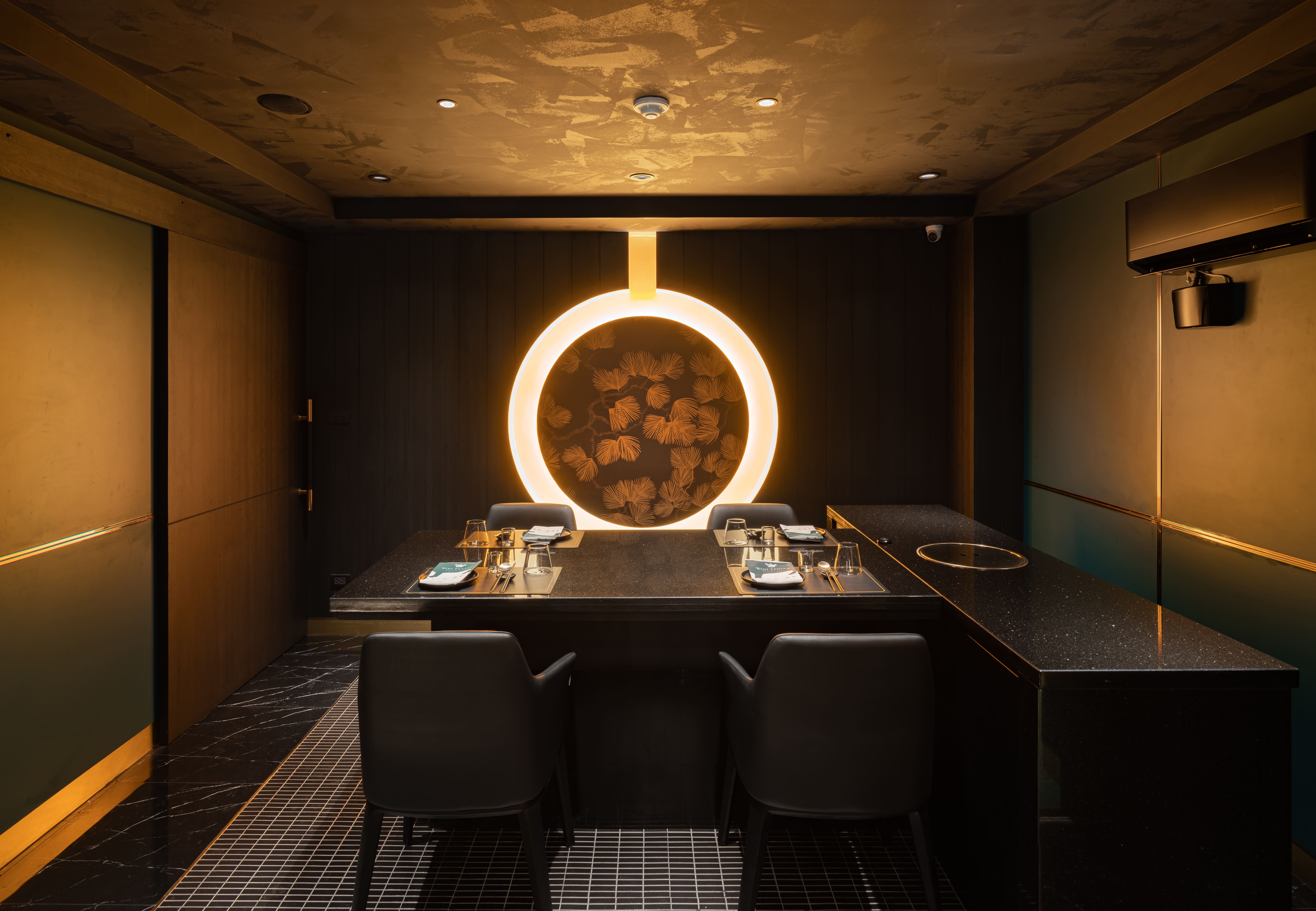 Lit ring stacked with yakisugi-charred hinoki behind a private dining table at Woo Tender