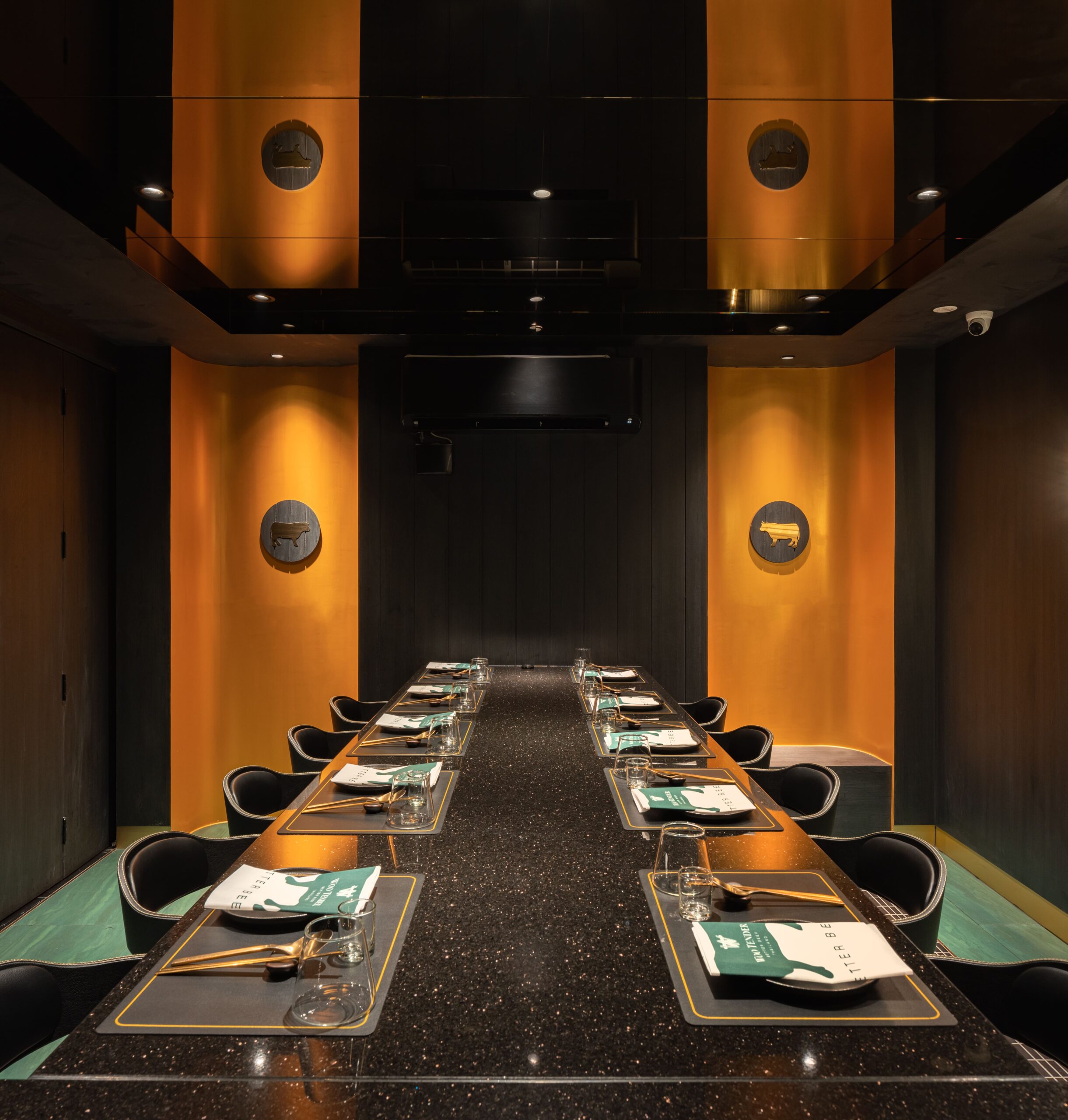 Long communal grill table under amber-lit portholes