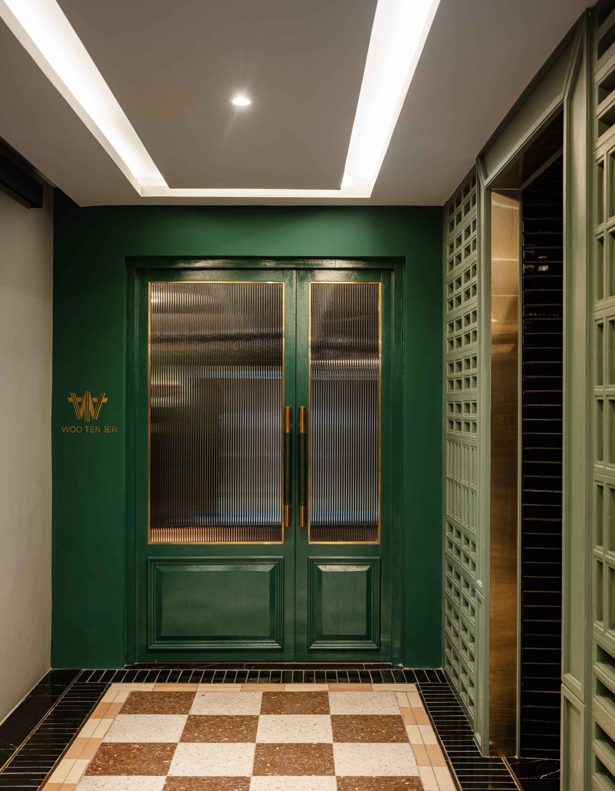 Green lacquered entrance door with reeded glass, lit from within