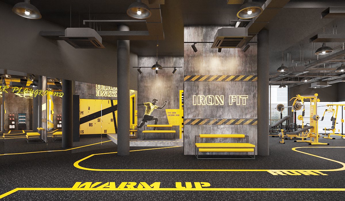 Ironfit training floor — yellow strength machines on black rubber flooring, exposed services ceiling, mirrored walls and hazard-stripe concrete wall, interior design by Gratitude Design