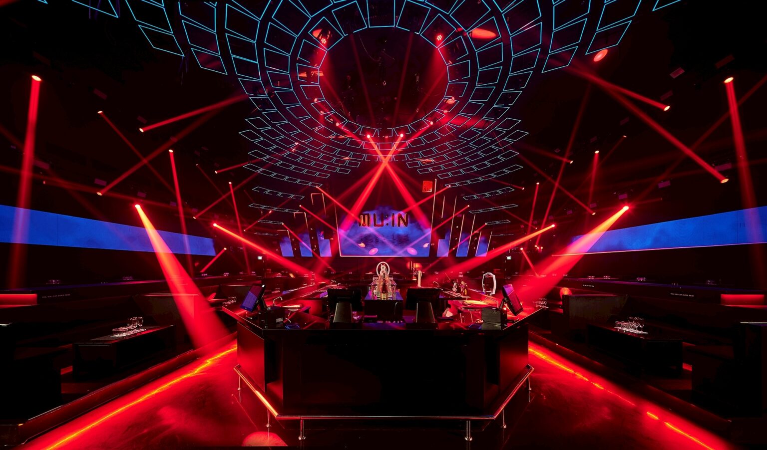MU:IN Bangkok nightclub interior design — The stage and DJ booth under beam lighting