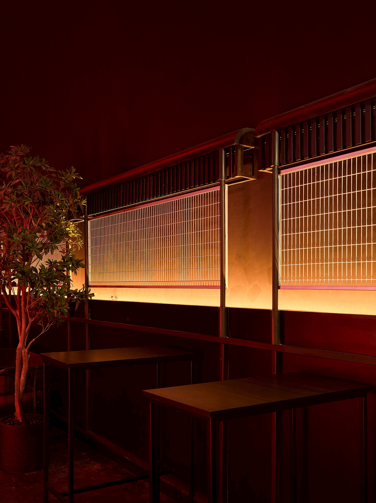 MU:IN Bangkok nightclub interior design — Material detail — woven steel mesh, warm light and a living tree