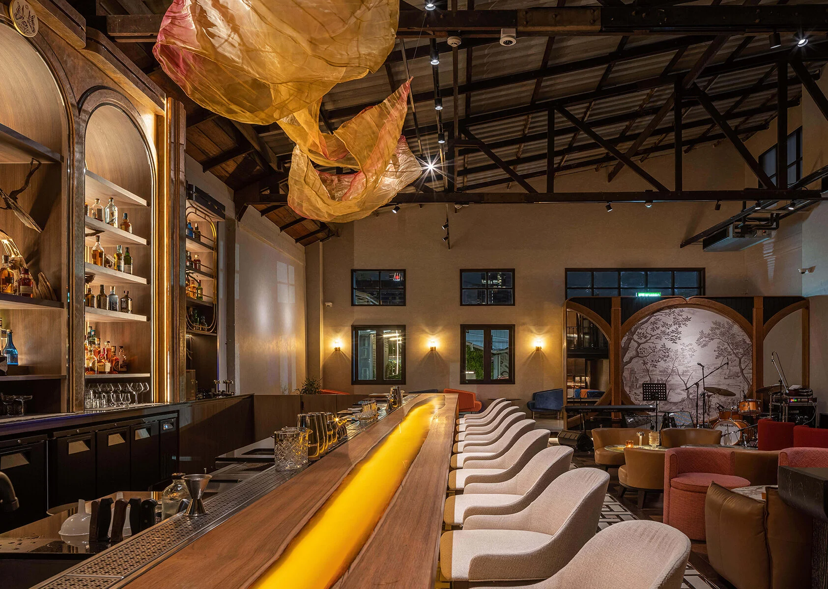 Live-edge timber bar counter with recessed amber lighting at Kilik Social Club, Bangkok