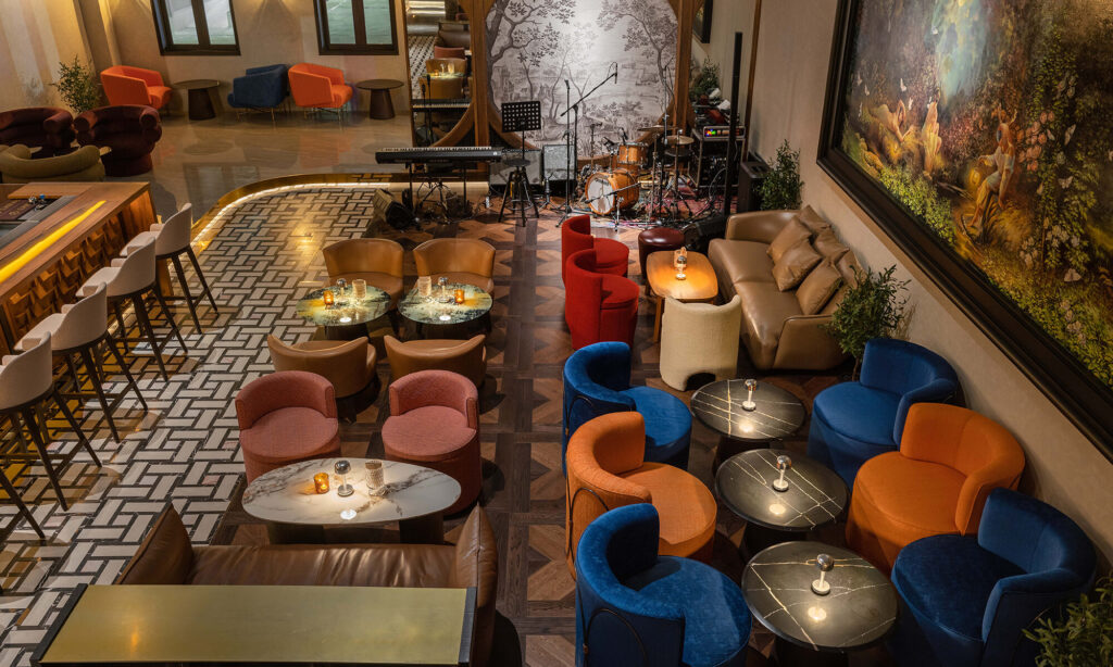 Overhead view of blue, red and cognac lounge seating around the live-music stage at Kilik Social Club