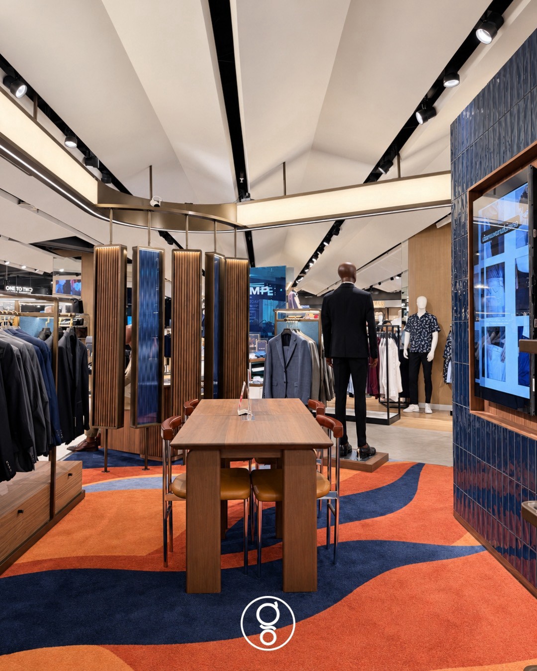 View through the hanging walnut and ribbed glass screens to the consultation table, folded white ceiling with track lighting above