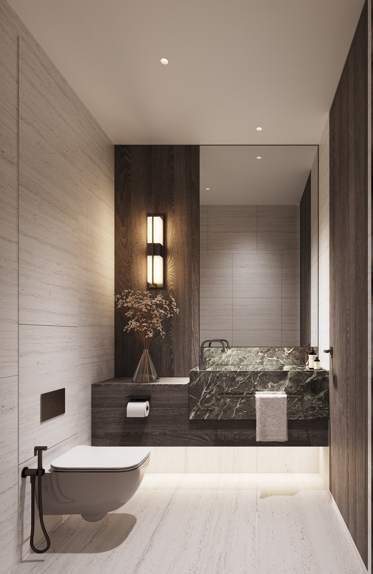 Thonglor Residence powder room — a green marble basin block on a dark timber shelf, a full-height mirror, a wall light and pale stone walls